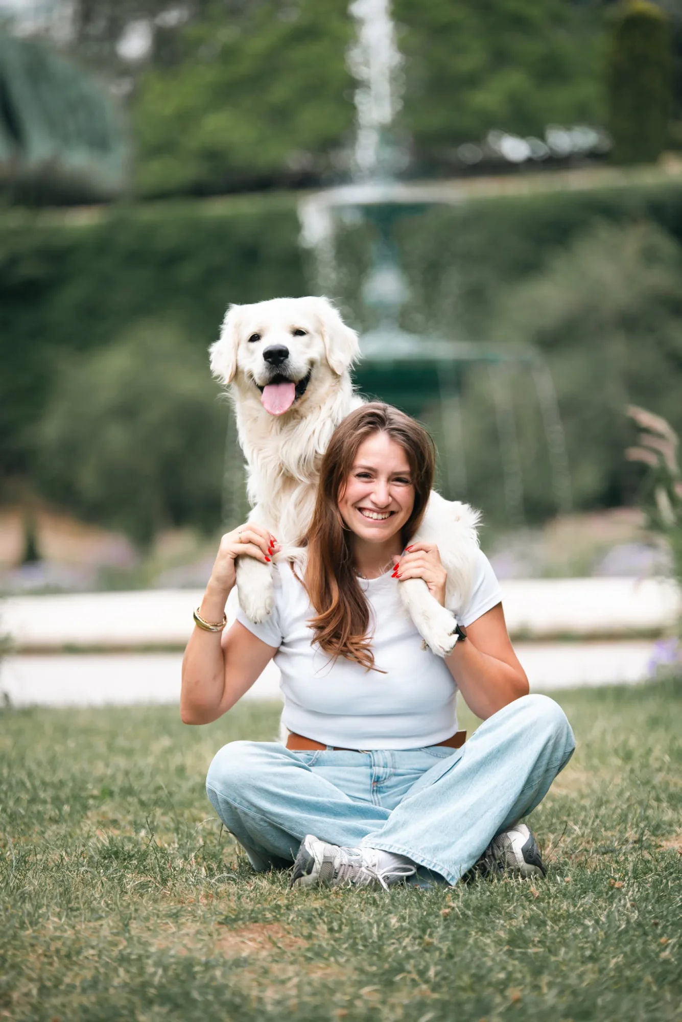 Jeune femme assise avec un chien blanc sur les épaules