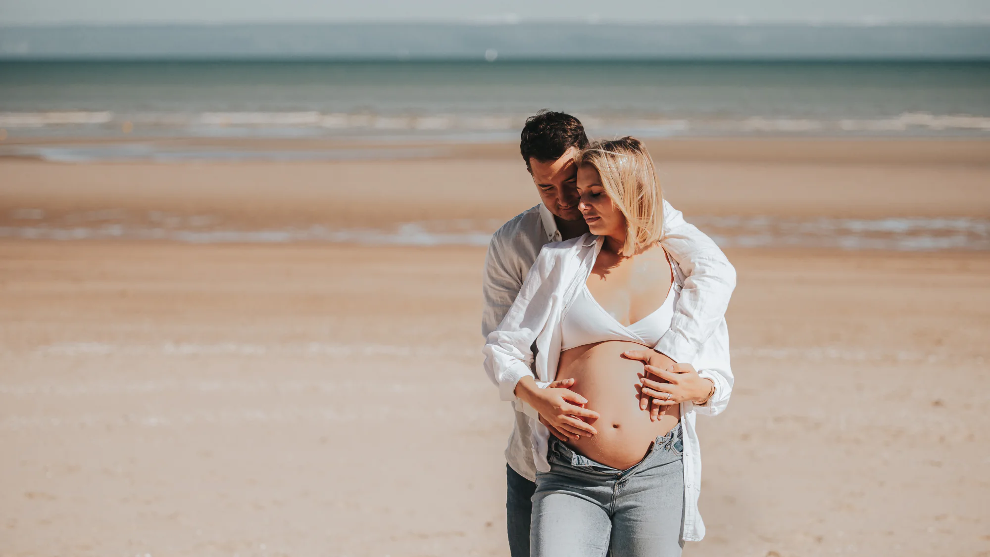 Couple attendant un enfant sur la plage
